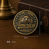 A round brass enamel pin featuring an American eagle design and the text 1776-2026 surrounded by stars.