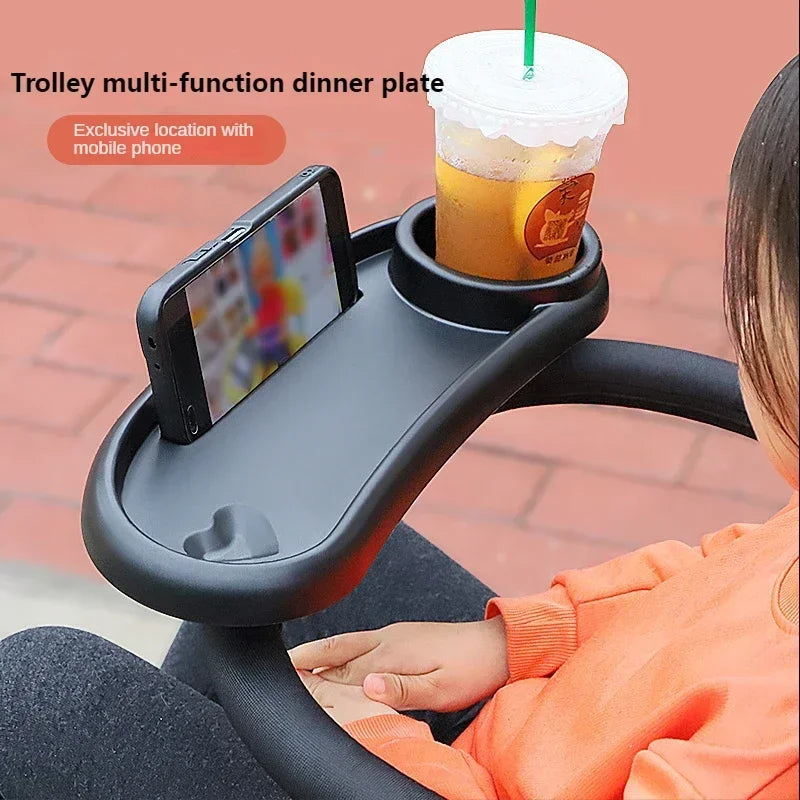 A black multi-function dinner plate tray is shown holding a mobile phone and a beverage cup on a person's lap.