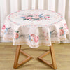 Vintage floral tablecloth with pink and blue roses on a round dining table.
