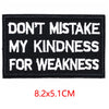 Black embroidered iron-on letter patch with white text that reads Don't mistake my kindness for weakness
