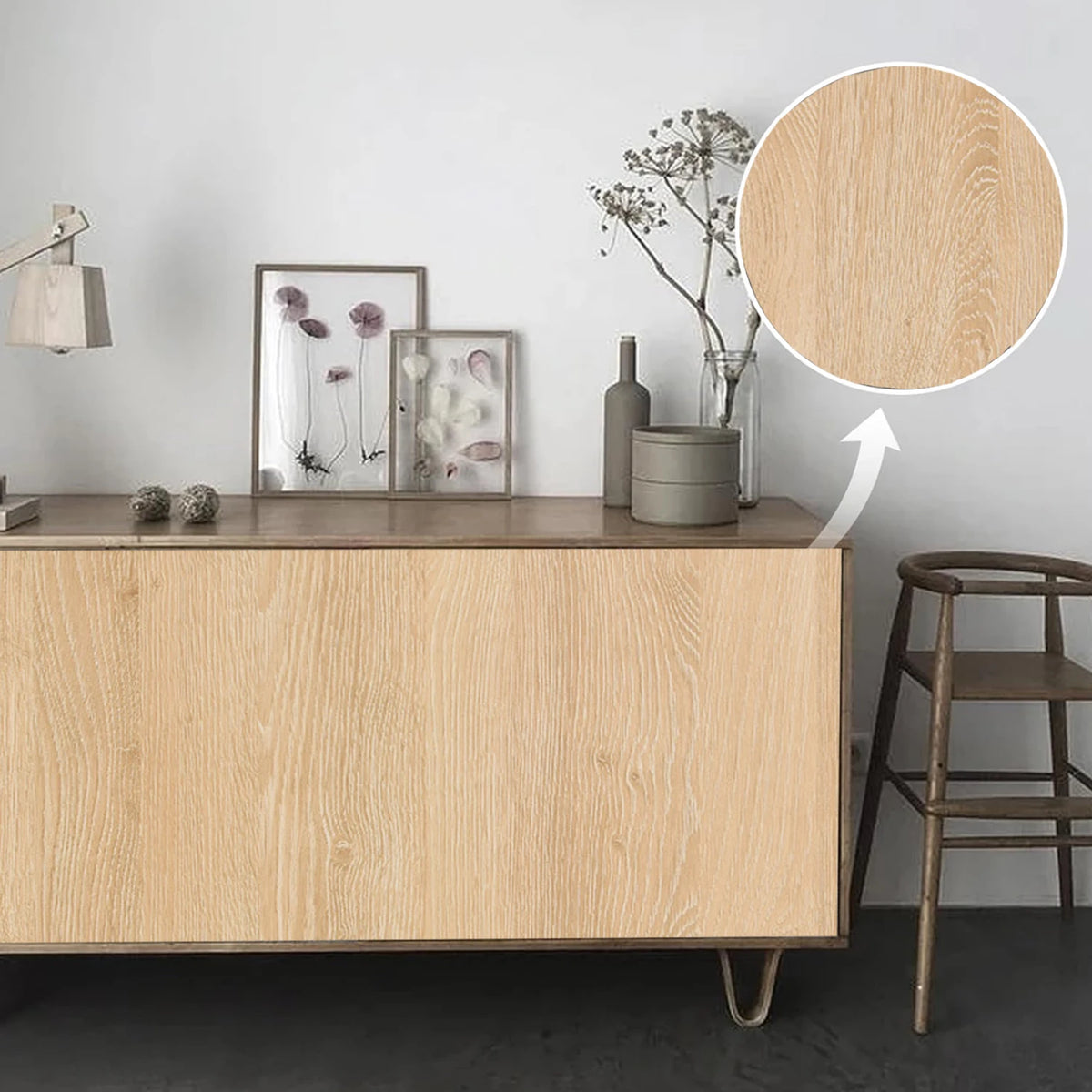 A light wood grain wallpaper roll displayed on a wooden cabinet with decorative items and a plant.
