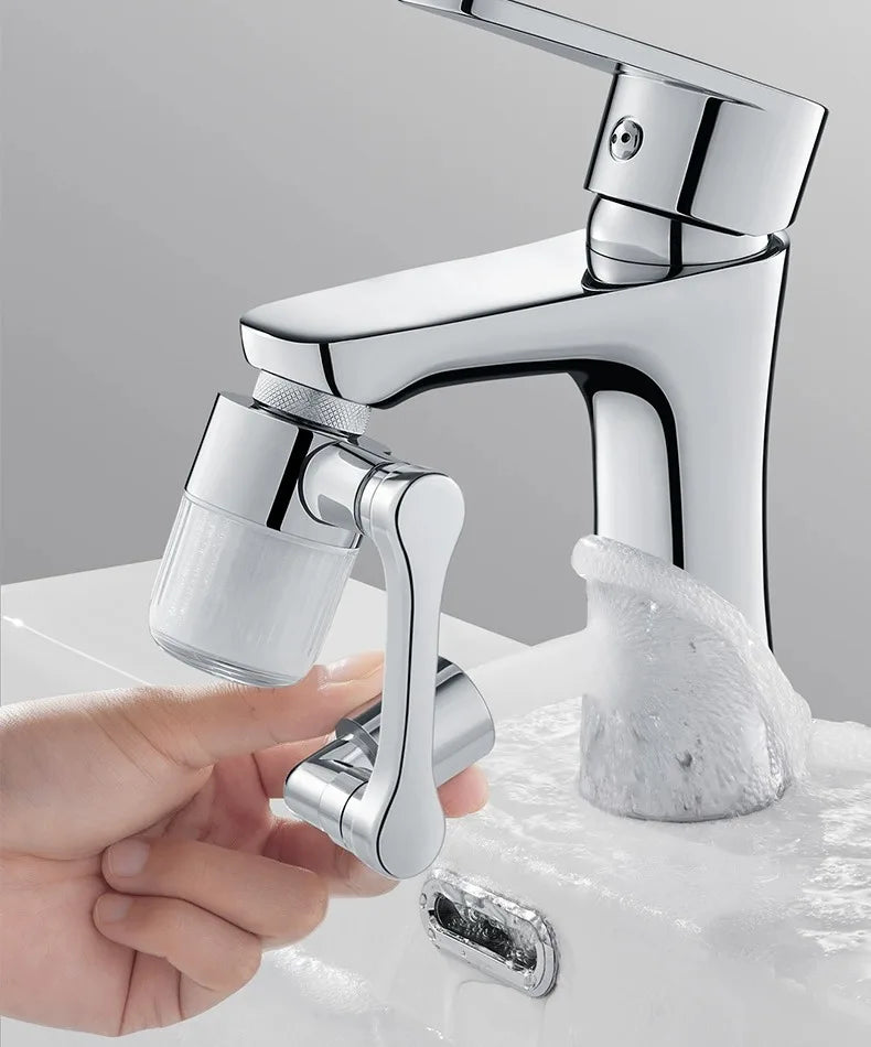 A hand holds a chrome faucet extender with a spray head, demonstrating its use.