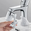 A hand holds a chrome faucet extender with a spray head next to a faucet body.