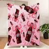 A pink throw blanket featuring a repeating pattern of Dr. Pepper bottles with pink ribbons.