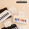 A set of DEIGA MUSIC electronic keyboards and sheet music for children, featuring colorful lights and musical notes.