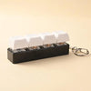 A black keychain holder containing several white LED mechanical fidget toys.