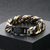 A chunky stainless steel Cuban chain bracelet featuring alternating black and gold links displayed on a dark surface.