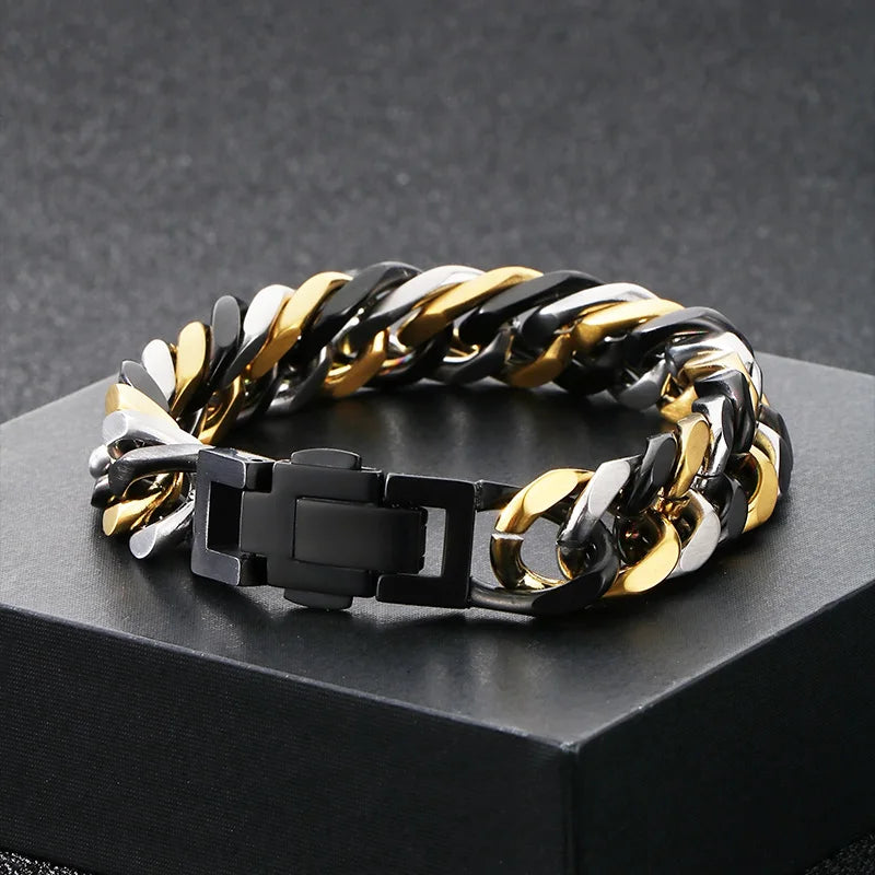A chunky stainless steel Cuban chain bracelet featuring alternating black and gold links displayed on a dark surface.