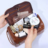 A brown leather toiletry bag is open, displaying various cosmetic and grooming products.