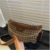 Braune Leder-Leopardenmuster-Crossbodytasche auf dunkler Fläche am Fenster.