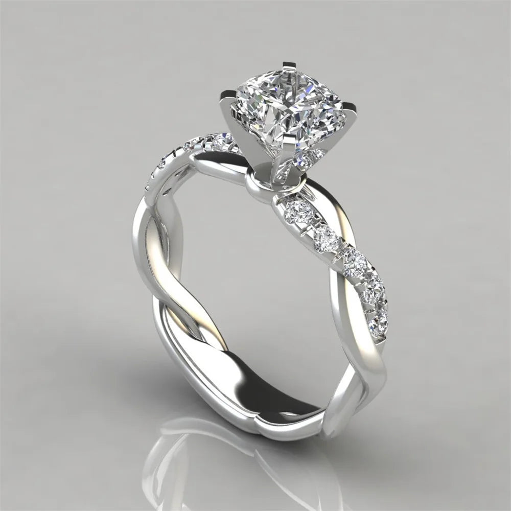Anillo de compromiso con circonitas de corte princesa bicolor plateado y una solitario de diamante.
