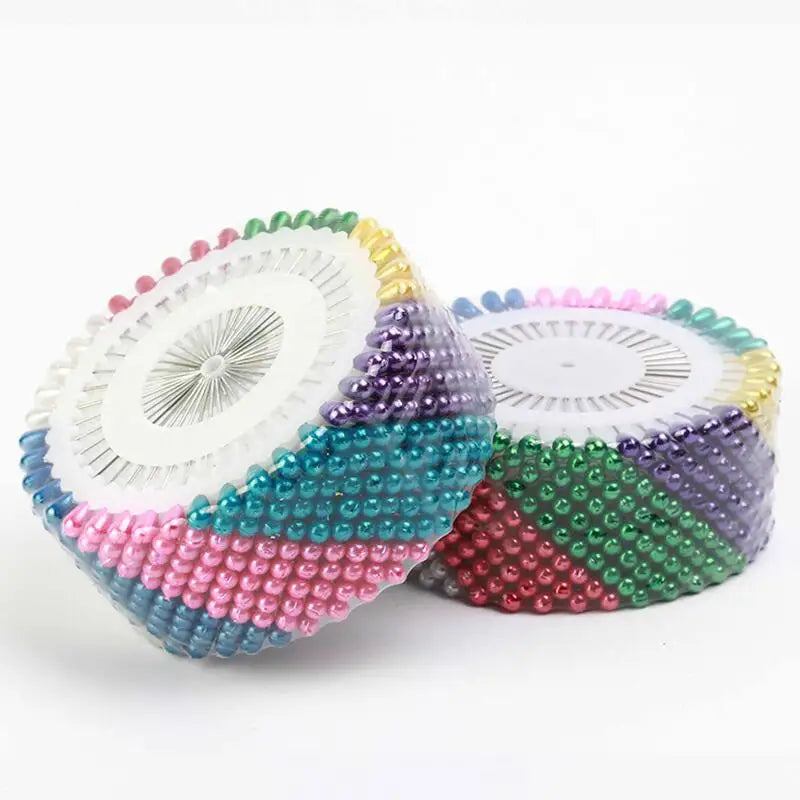 A collection of colorful round pearl straight pins in various shades including pink, blue, green, and purple.