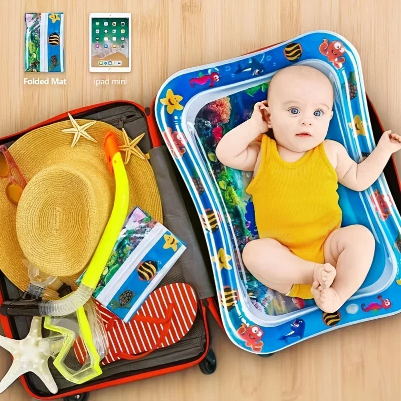 A baby is sitting in a blue inflatable water play mat surrounded by toys and a folded mat.