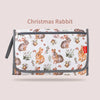 A white fabric pouch featuring a Christmas rabbit pattern, used as a foldable baby changing mat with a waterproof cover and s
