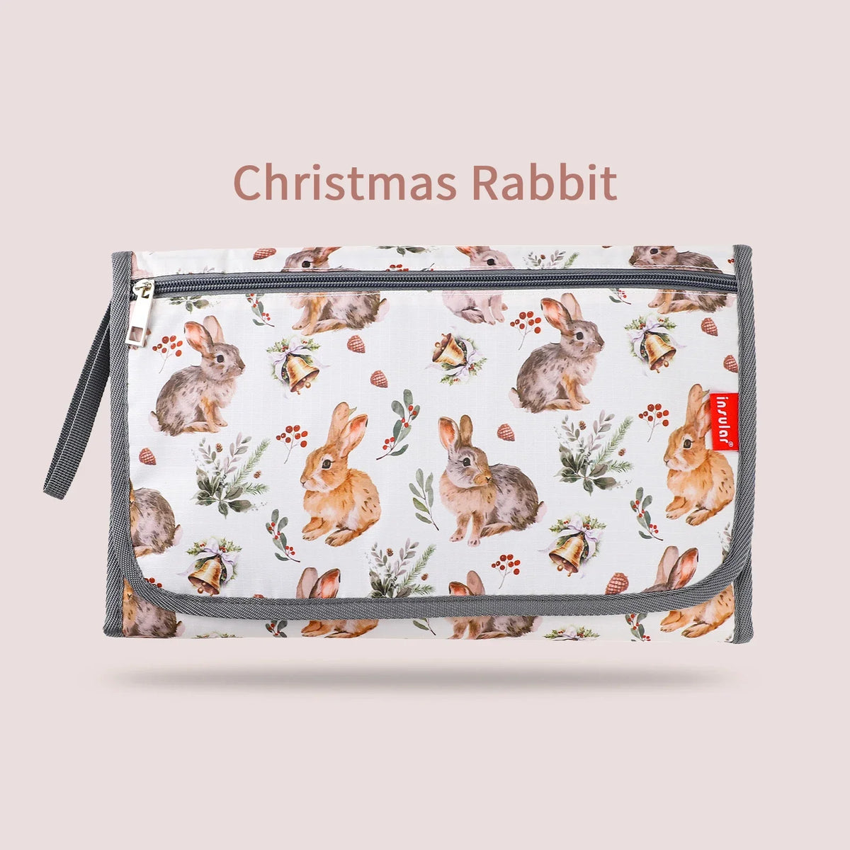 A white fabric pouch featuring a Christmas rabbit pattern, used as a foldable baby changing mat with a waterproof cover and s
