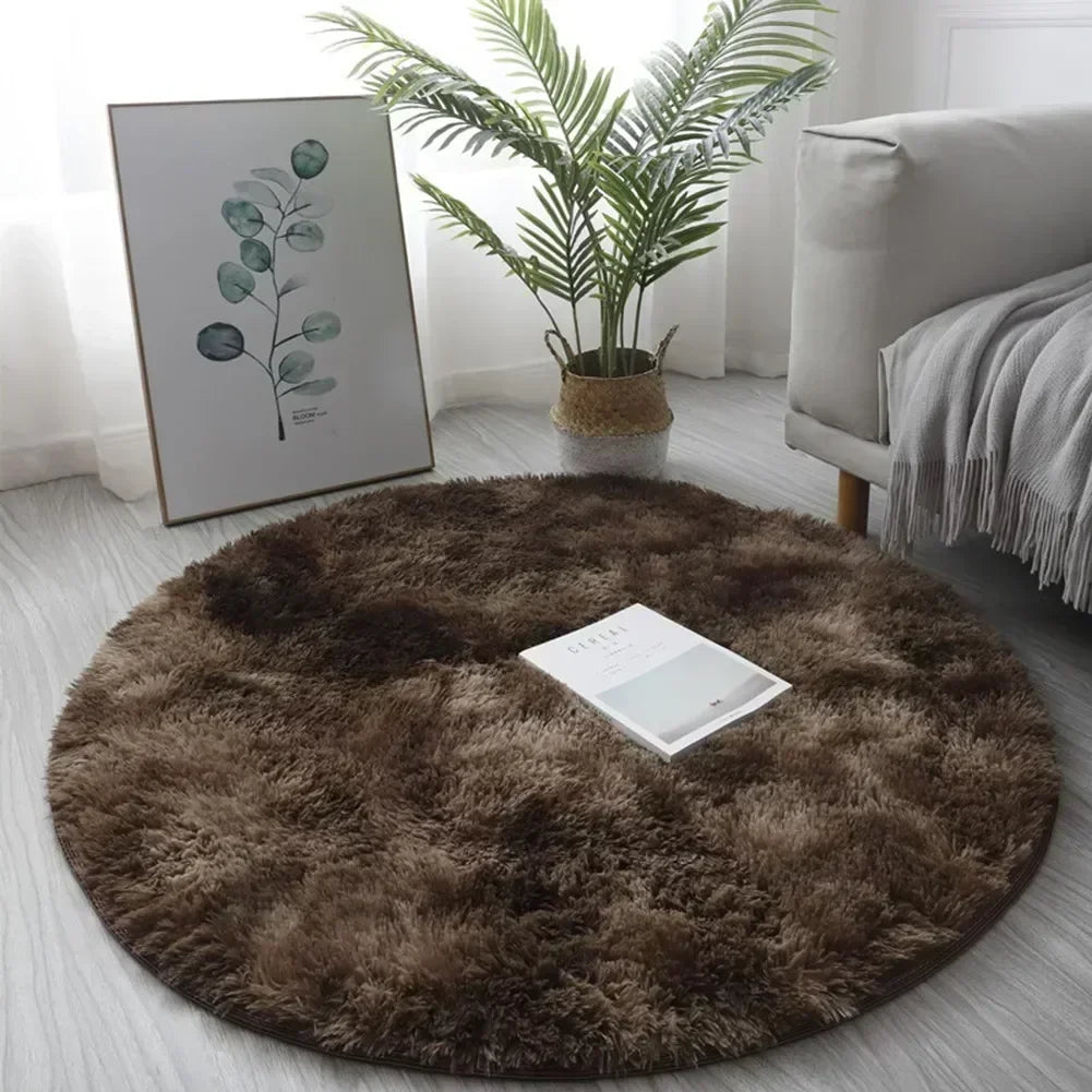 A round, dark brown shaggy area rug placed on a light wooden floor next to a potted plant and framed artwork.
