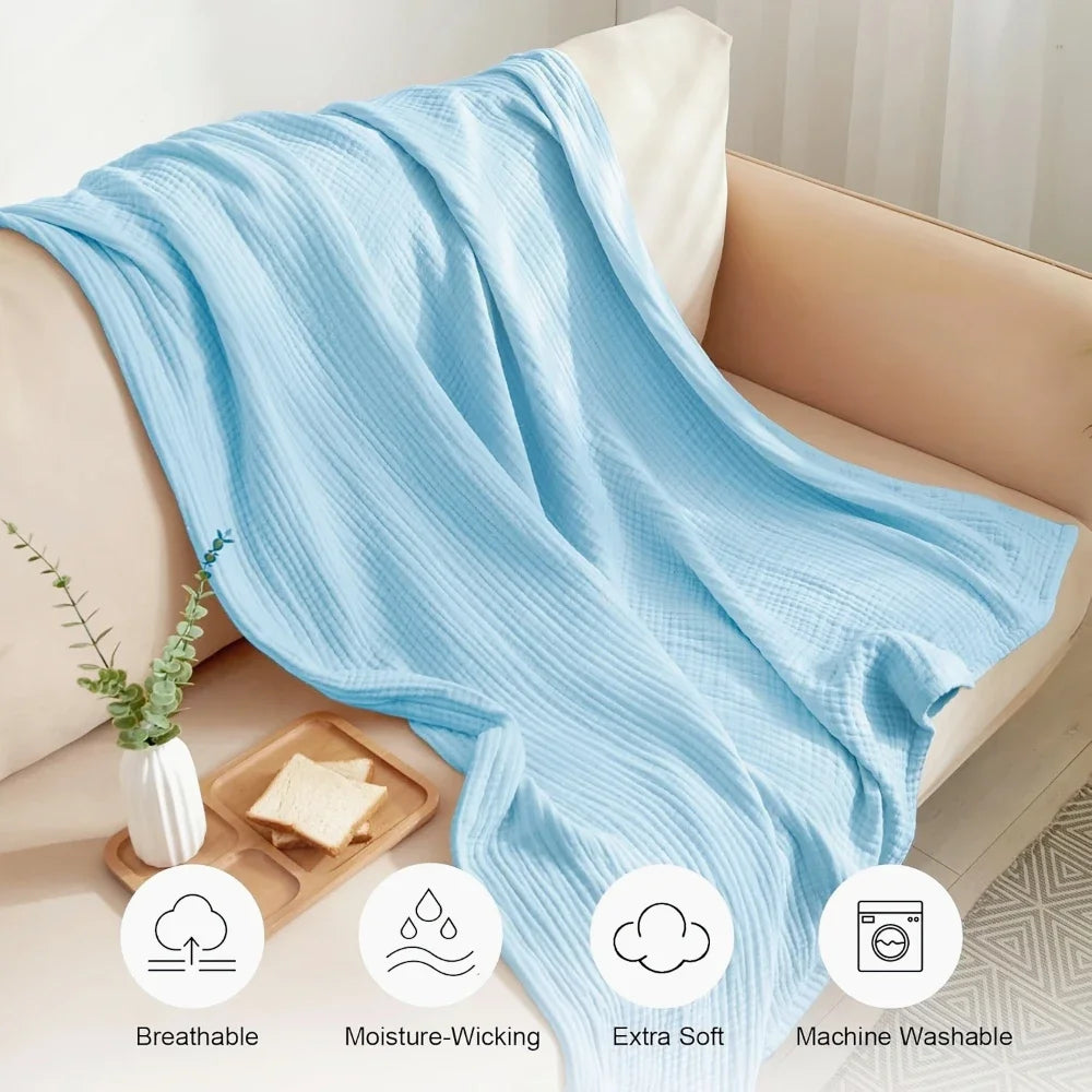 Hellblaue atmungsaktive, feuchtigkeitsableitende, extra weiche Baumwollgaze-Decke über einem Sofa drapiert.