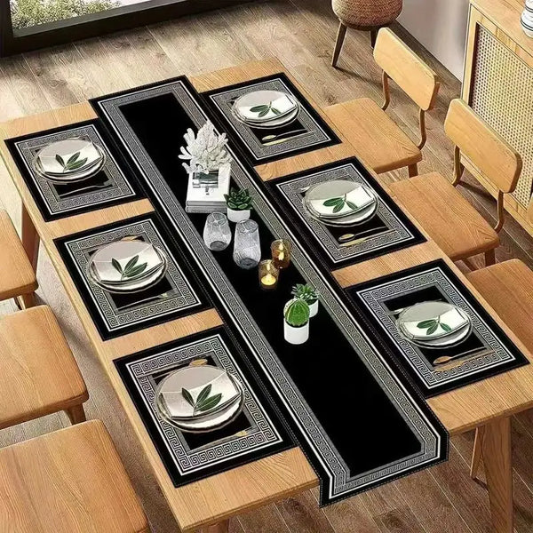 A set of waterproof geometric table runners and placemats featuring a black and gold design on a wooden table.