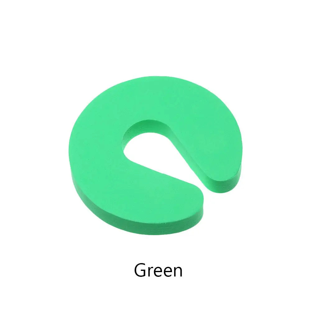 A bright green foam door stopper with a curved shape designed for finger pinch protection.