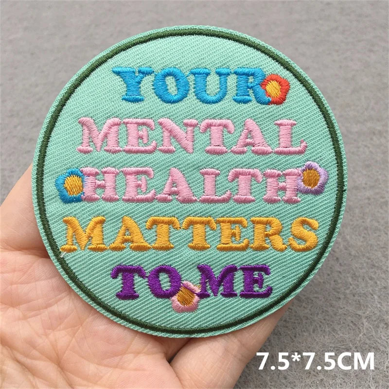 A round embroidered patch with text reading YOUR MENTAL HEALTH MATTERS TO ME in various colored thread on a green fabric back