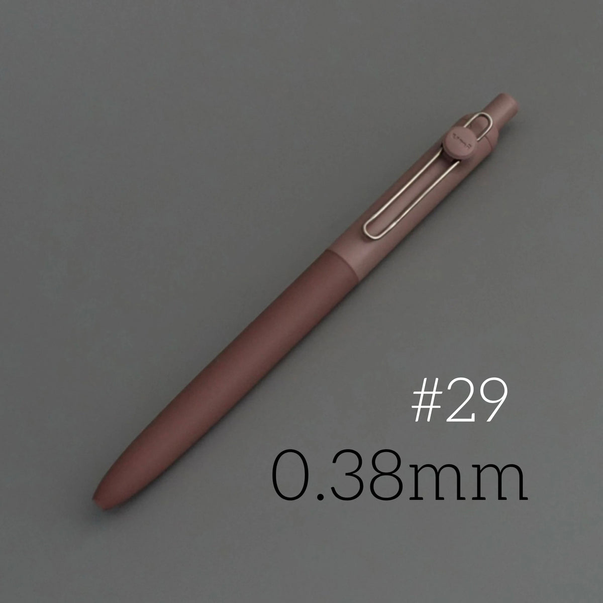 A close-up view of a rose-colored Uni ZENTO Quick-Dry Gel Pen with a metallic tip, labeled #29 and 0.38mm.
