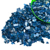 Dark blue tumbled crystal stone chips scattered on a green bowl
