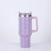 A purple rhinestone bling tumbler with a silver lid, straw, and handle.