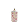A ceramic storage jar with a pink and cream checkerboard pattern and a gold lid.