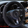 Black breathable faux leather steering wheel cover with diamond accents inside a car interior.