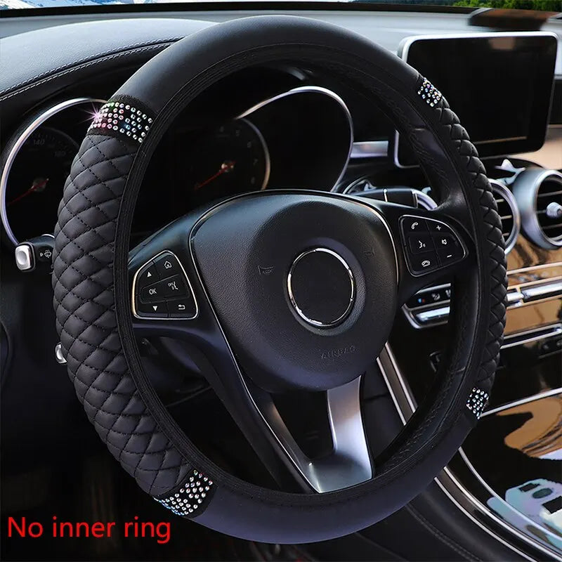 Black breathable faux leather steering wheel cover with diamond accents inside a car interior.