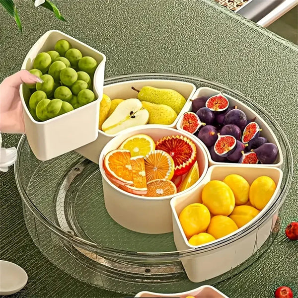 Una bandeja giratoria dividida llena de frutas frescas como uvas verdes, manzanas y rodajas de cítricos.