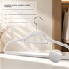 A white velvet non-slip hanger with a chrome-plated heavy-duty hook is displayed on a wooden surface.