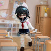 An articulated BJD collectible figurine with black hair and a white school uniform is shown standing on a wooden floor.