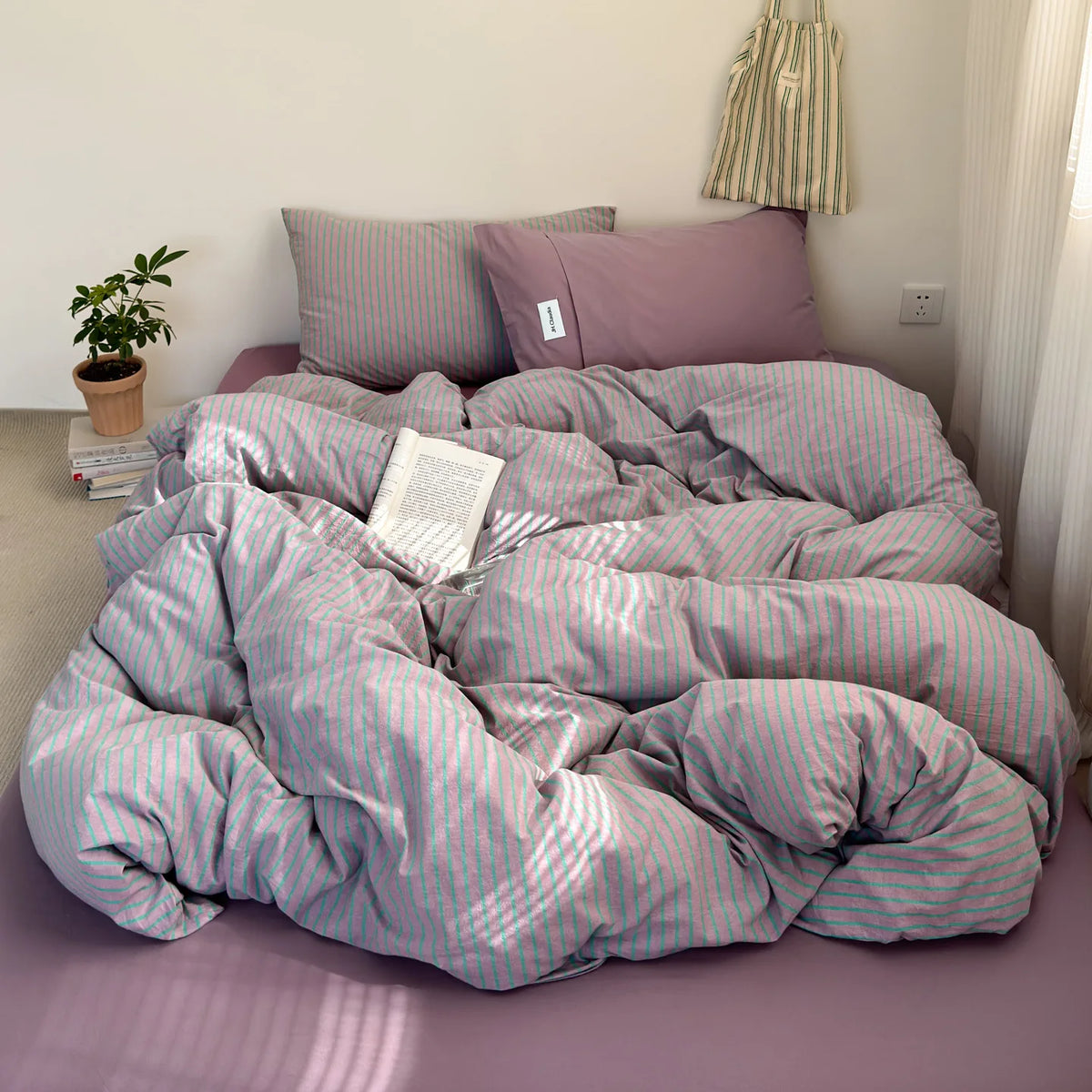 A lilac and white striped duvet cover set is displayed on a bed with soft lighting.