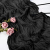 Black cotton gauze table runner draped with dark fabric and pink roses, featuring black utensils.