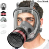 A man wearing a gray full face respirator mask with a black gas filter canister.