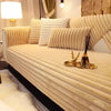 A beige plush sofa cushion mat with vertical ribbed texture rests on a light-colored sofa.