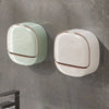 Wall mounted waterproof soap dish with drainage in pale green and white on a gray wall.