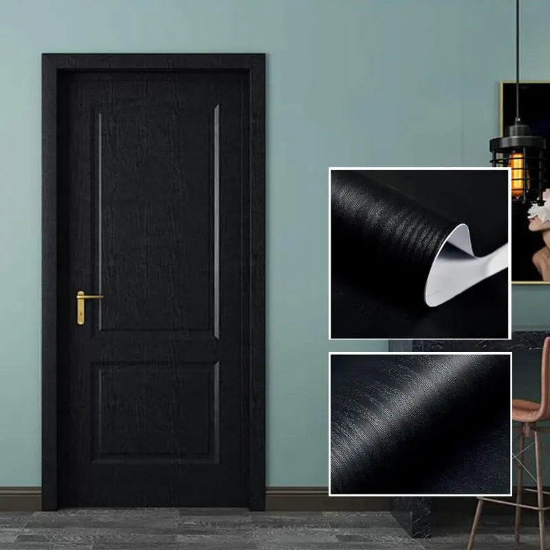 A close-up view of a matte black door with vertical wood grain texture and a gold handle, next to samples of the self-adhesiv