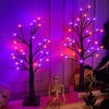 An LED Halloween birch tree with orange and purple lights displayed against a dark background.