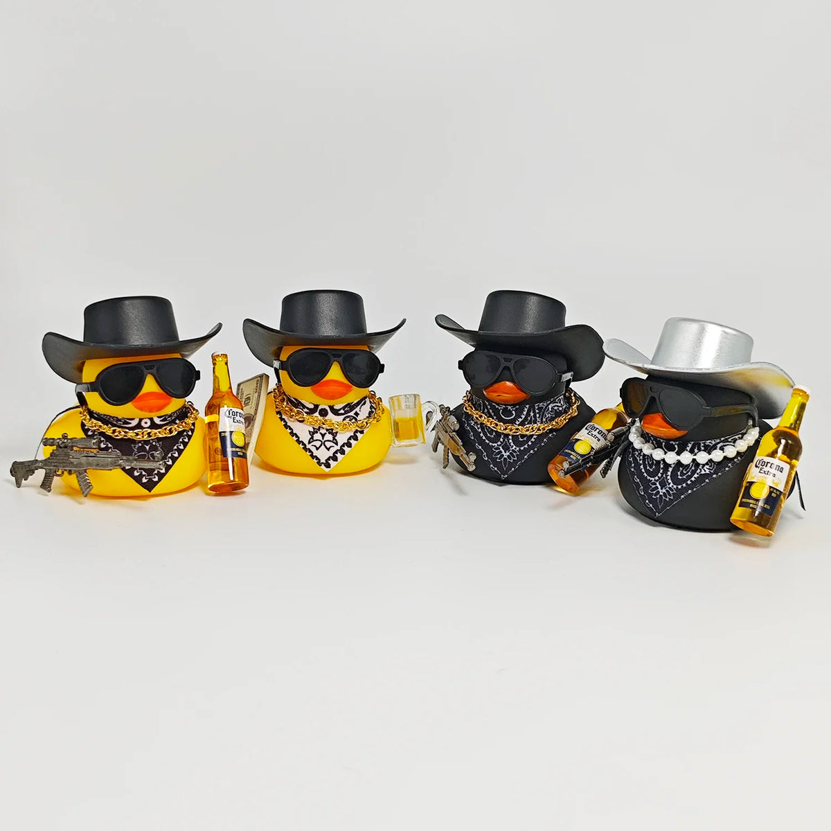 A set of four cowboy rubber duck car ornaments featuring yellow and black patterns, hats, sunglasses, and bottles.