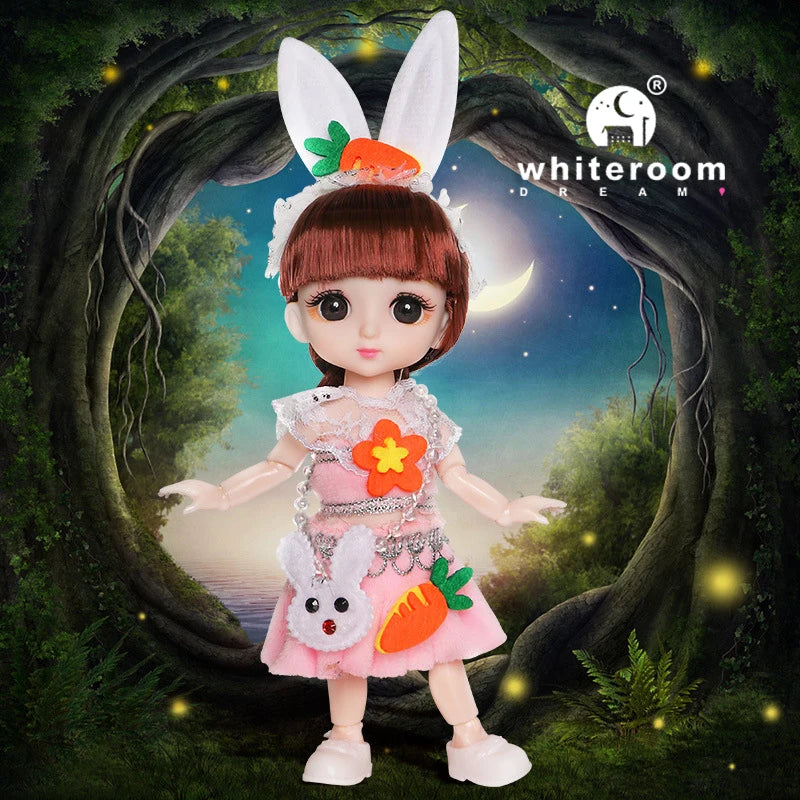 A pink fashion doll with white ears and orange accents stands in a natural, leafy setting.