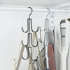 A black metal hanging organizer rack displaying various hats, bags, and scarves.