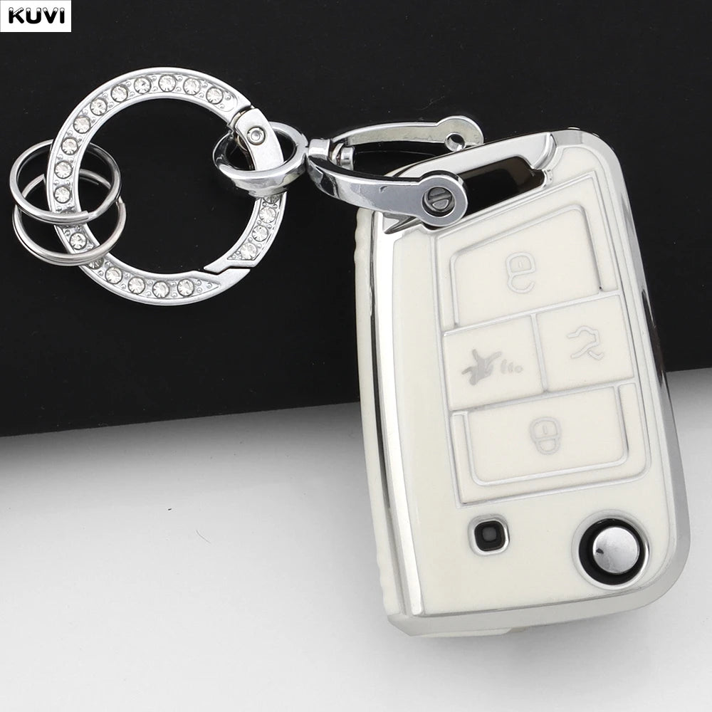 A silver car key fob with a circular ring attached, featuring multiple buttons and a protective cover.
