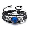 Black leather wrap bracelet featuring a blue zodiac sign charm and silver accents.