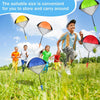 Children playing outdoors with colorful hand-thrown parachute toys in a grassy field.
