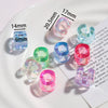 A collection of colorful acrylic alphabet beads and findings displayed on a white plate.