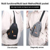A black and gray multi functional bag shown being worn on one shoulder and diagonally across a light colored jacket.