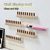 A wall display rack featuring multiple rows of clear acrylic bottles and tubes for organizing cosmetics or similar products.