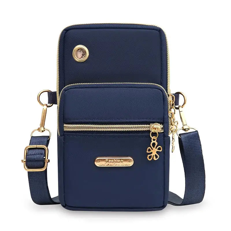 Bolso cruz impermeable de nylon azul marino con detalles dorados y cremallera.